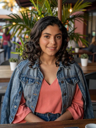 Karla, 24, Salvadoran single from San Salvador smiling at an outdoor tropical cafe